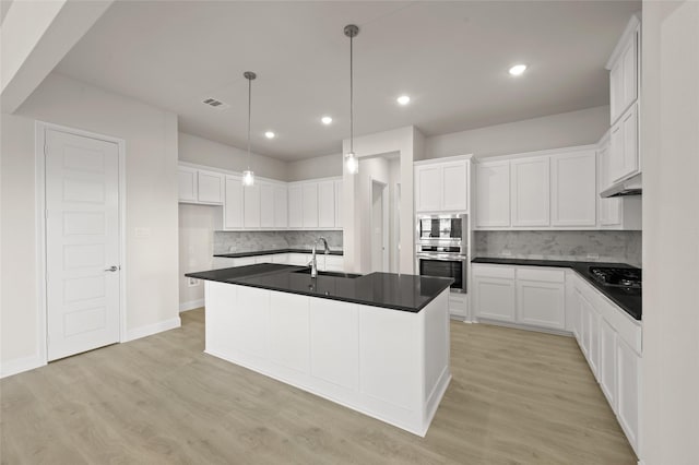 2413 Rams Horn, Waxahachie, TX 75167 - kitchen featuring dark countertops, tasteful backsplash, light wood-type flooring, and visible vents