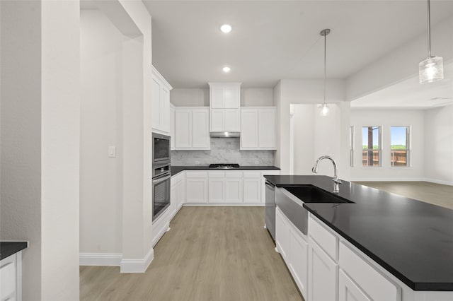 2413 Rams Horn, Waxahachie, TX 75167 - kitchen with decorative backsplash, stainless steel appliances, dark countertops, light wood finished floors, and a sink