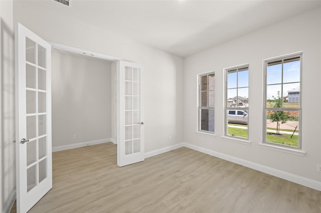 2413 Rams Horn, Waxahachie, TX 75167 - empty room with baseboards, light wood-type flooring, and french doors