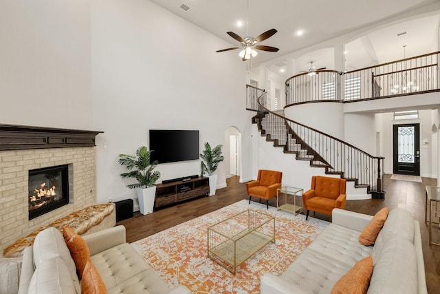 14662 Gentle Breeze Rd, Frisco, TX 75035 - living area featuring a towering ceiling, stairs, ceiling fan, arched walkways, and wood finished floors