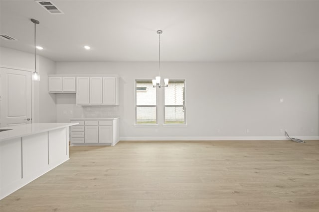2297 High Plain Ln, Waxahachie, TX 75167 - kitchen featuring white cabinetry, light wood-style flooring, baseboards, recessed lighting, and hanging light fixtures