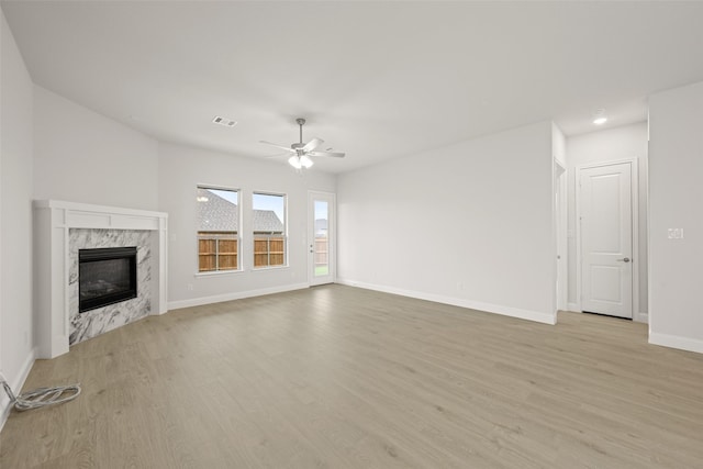 2297 High Plain Ln, Waxahachie, TX 75167 - unfurnished living room with light wood-type flooring, baseboards, ceiling fan, and a high end fireplace