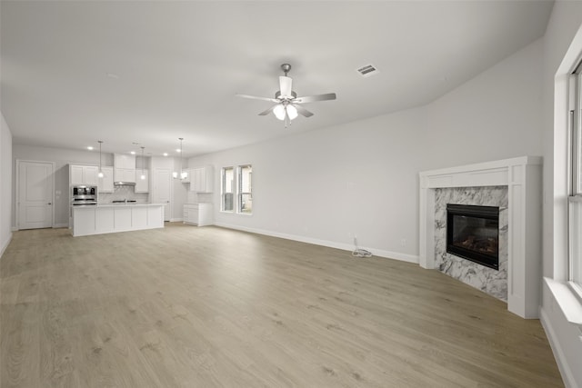 2297 High Plain Ln, Waxahachie, TX 75167 - unfurnished living room featuring a premium fireplace, recessed lighting, light wood finished floors, a ceiling fan, and baseboards