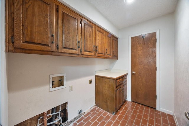 laundry room with cabinet space, brick floor, hookup for an electric dryer, and hookup for a washing machine