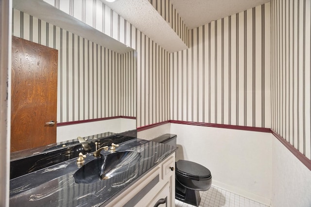 bathroom featuring toilet, tile patterned floors, wallpapered walls, and vanity