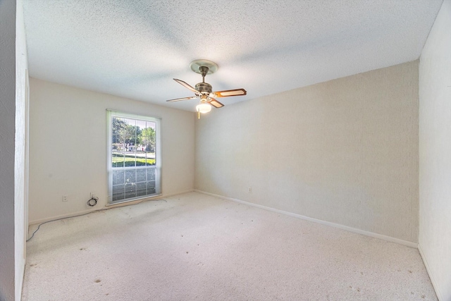 empty room with a textured ceiling, ceiling fan, baseboards, and carpet