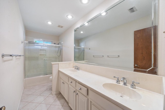 full bathroom with double vanity, enclosed tub / shower combo, toilet, visible vents, and a sink