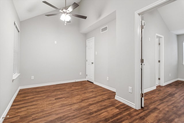 spare room featuring vaulted ceiling, ceiling fan, dark wood finished floors, and baseboards