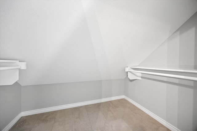 walk in closet featuring vaulted ceiling