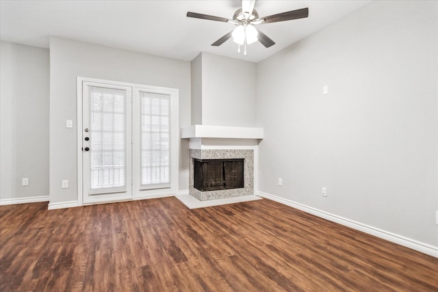 unfurnished living room featuring dark wood finished floors, a fireplace, and baseboards