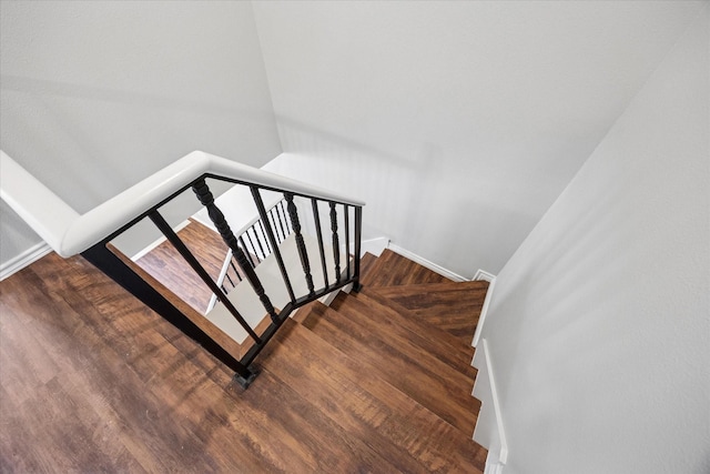 stairway with baseboards and wood finished floors