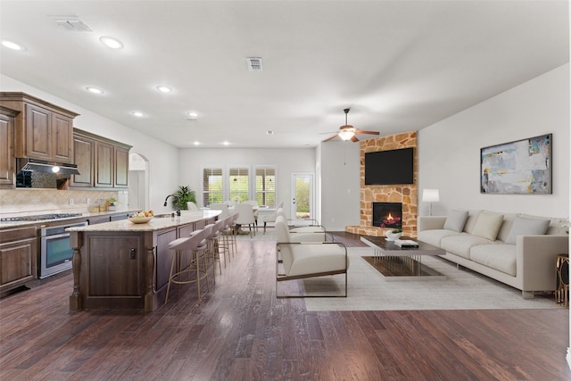 109 Joplin Dr, Mckinney, TX 75071 - living room featuring visible vents, a stone fireplace, a ceiling fan, and dark wood-style floors