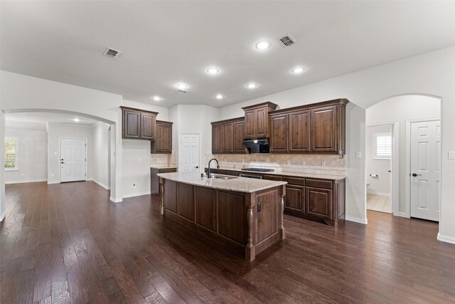 109 Joplin Dr, Mckinney, TX 75071 - kitchen featuring dark wood finished floors, arched walkways, visible vents, a sink, and backsplash