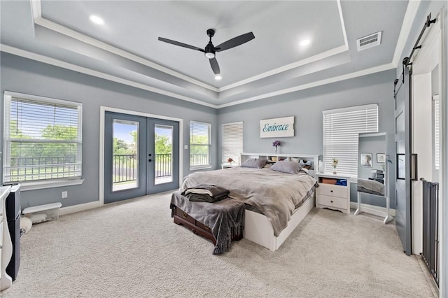 10281 Creekside Ln, Waco, TX 76712 - bedroom with a barn door, a tray ceiling, access to exterior, french doors, and multiple windows