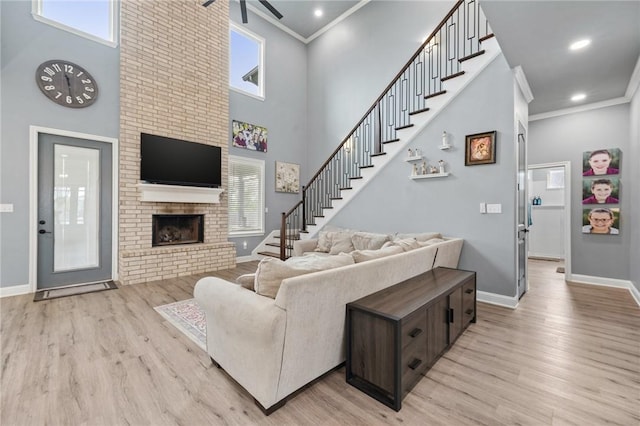 10281 Creekside Ln, Waco, TX 76712 - living room featuring plenty of natural light, light wood-style floors, baseboards, ornamental molding, and a fireplace