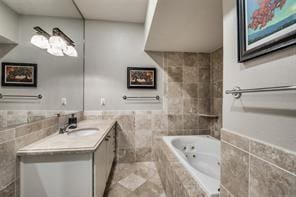 full bath with tile walls, a tub with jets, wainscoting, and vanity