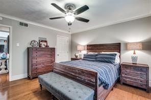 bedroom featuring wood finished floors, baseboards, a ceiling fan, and visible vents
