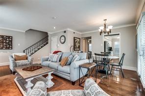 living area featuring crown molding, baseboards, stairway, and a chandelier