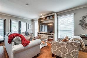 living area featuring ornamental molding and wood finished floors