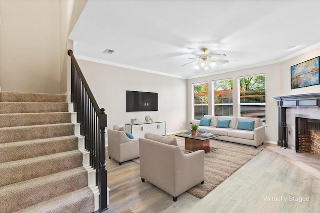 110 Harvest Bend Dr, Wylie, TX 75098 - living room with light wood-style flooring, ornamental molding, stairway, ceiling fan, and a fireplace with flush hearth