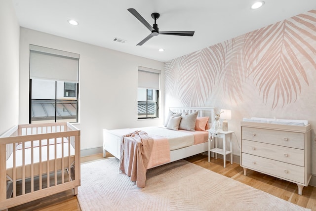 7158 Pasadena Ave, Dallas, TX 75214 - bedroom featuring wallpapered walls, an accent wall, baseboards, recessed lighting, and wood finished floors