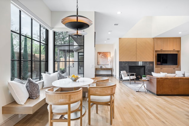 7158 Pasadena Ave, Dallas, TX 75214 - kitchen featuring light brown cabinets, stainless steel microwave, light wood finished floors, healthy amount of natural light, and recessed lighting