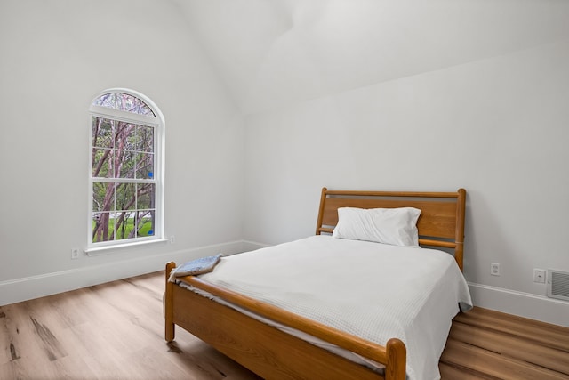 1190 Emerald Sound Blvd, Oak Point, TX 75068 - bedroom with wood finished floors, vaulted ceiling, and baseboards