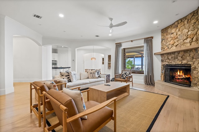 1190 Emerald Sound Blvd, Oak Point, TX 75068 - living room featuring arched walkways, a ceiling fan, light wood-style floors, a fireplace, and recessed lighting