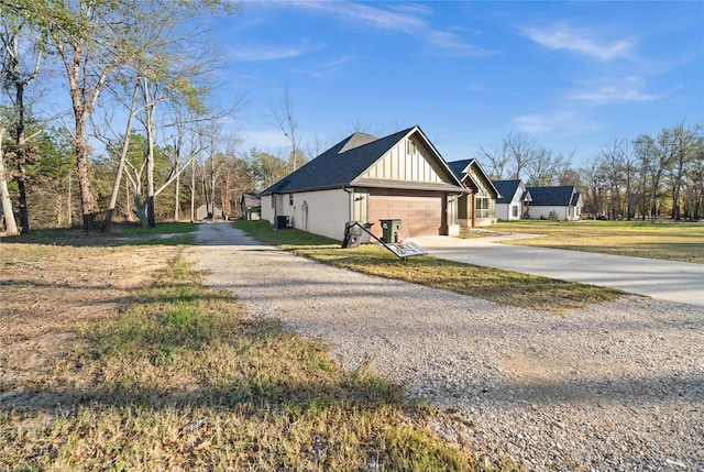 12908 County Road 463, Tyler, TX 75706 - view of property exterior with board and batten siding, a lawn, a garage, and concrete driveway