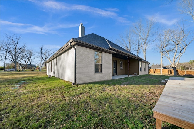 12908 County Road 463, Tyler, TX 75706 - back of house featuring a patio, a chimney, brick siding, fence, and a lawn