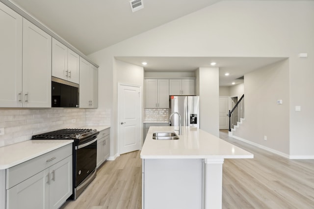 kitchen featuring light wood-style flooring, visible vents, a sink, light countertops, and appliances with stainless steel finishes