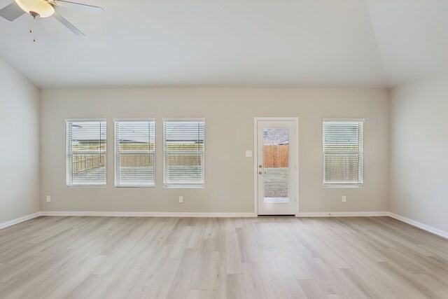 empty room with baseboards, light wood-style floors, a healthy amount of sunlight, and ceiling fan