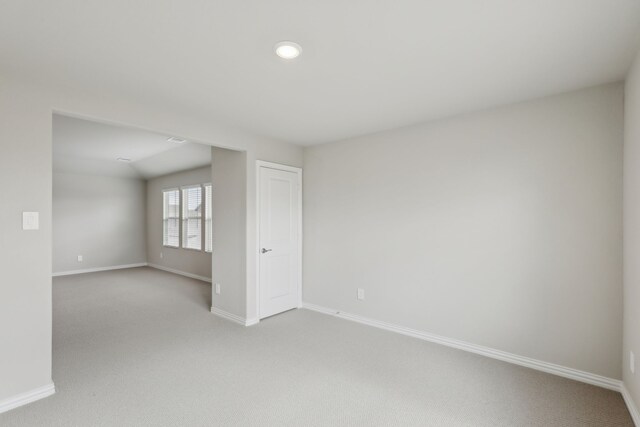 empty room with light carpet, baseboards, and recessed lighting