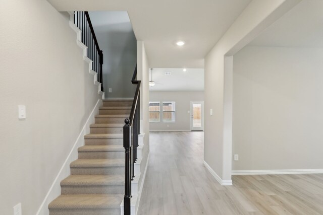 staircase with recessed lighting, baseboards, and wood finished floors