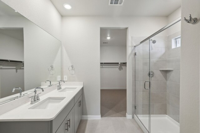 bathroom with a sink, a spacious closet, and a shower stall