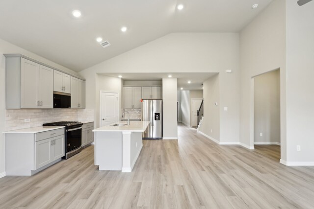 kitchen featuring a sink, stainless steel appliances, tasteful backsplash, and light countertops