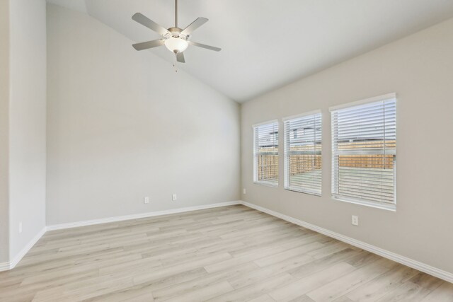 empty room with light wood finished floors, baseboards, a ceiling fan, and high vaulted ceiling