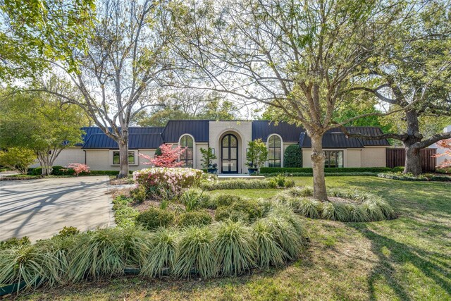 10989 Crooked Creek Dr, Dallas, TX 75229 - view of front of home with a front yard, metal roof, and a standing seam roof