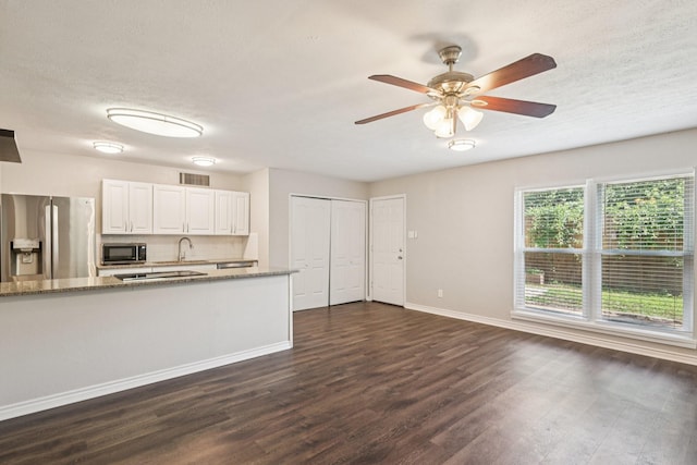 716 Meadow Mead Dr, Allen, TX 75002 - kitchen featuring stainless steel appliances, dark wood finished floors, light stone countertops, baseboards, and white cabinetry