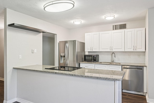716 Meadow Mead Dr, Allen, TX 75002 - kitchen featuring black appliances, a sink, light stone counters, dark wood-type flooring, and white cabinets