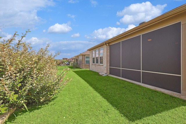 view of yard with fence and a sunroom