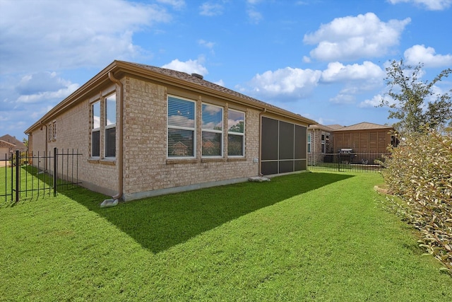 back of house with a yard, fence, and brick siding