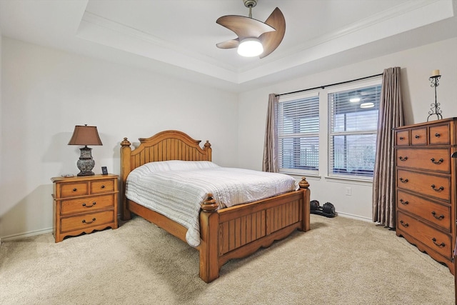 bedroom with light colored carpet, ornamental molding, a ceiling fan, a raised ceiling, and baseboards