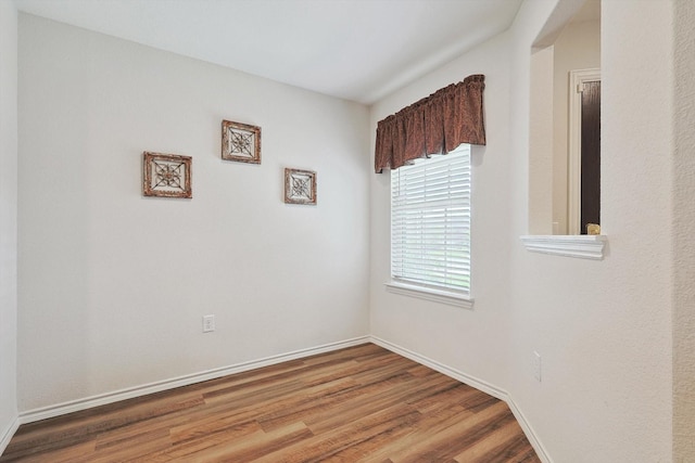 spare room featuring wood finished floors and baseboards