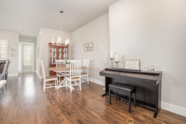 dining area with an inviting chandelier, dark wood finished floors, and baseboards