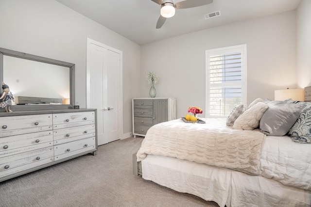 bedroom featuring a ceiling fan, visible vents, light carpet, and baseboards
