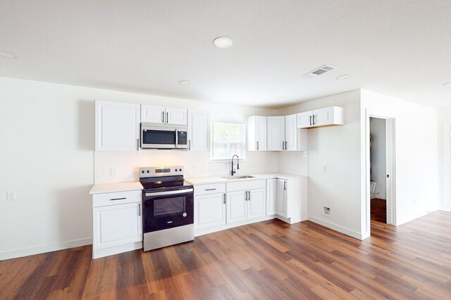 6840 Hillmont Dr, Dallas, TX 75217 - kitchen featuring a sink, light countertops, appliances with stainless steel finishes, and dark wood-style floors