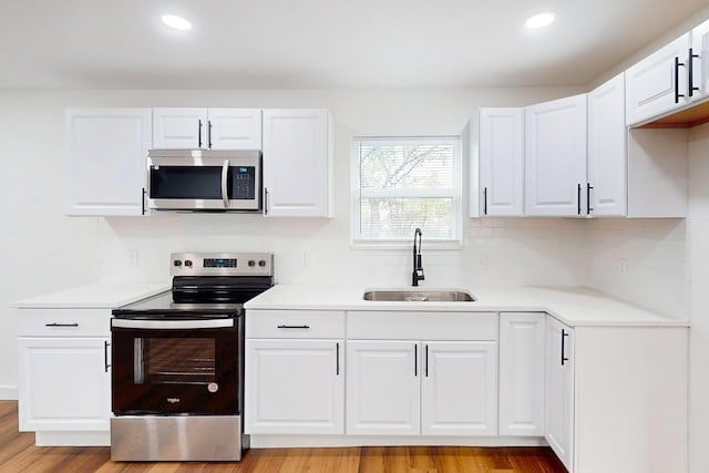 6840 Hillmont Dr, Dallas, TX 75217 - kitchen featuring a sink, light countertops, white cabinets, and stainless steel appliances