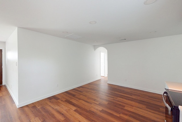 6840 Hillmont Dr, Dallas, TX 75217 - unfurnished room featuring arched walkways, wood finished floors, baseboards, and visible vents