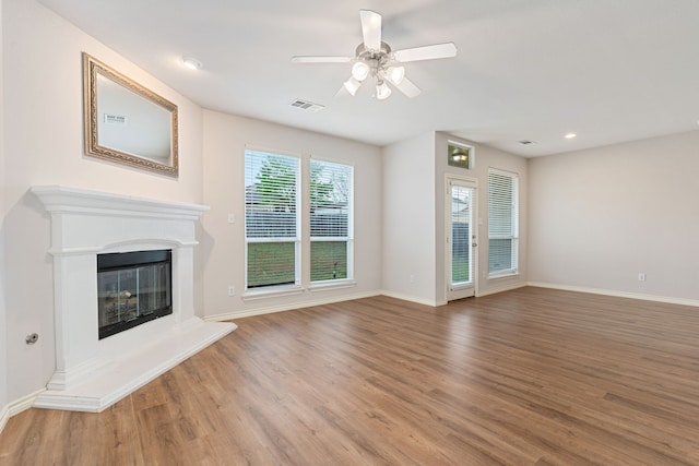 5013 Royal Burgess Dr, Fort Worth, TX 76135 - unfurnished living room with wood finished floors, visible vents, baseboards, a glass covered fireplace, and ceiling fan